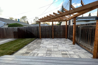 Inspiration for a small modern backyard brick and wood fence landscaping in Other with a pergola for summer.