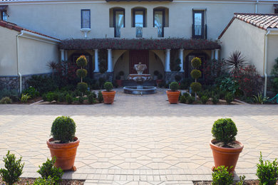 Photo of a mediterranean partial sun courtyard brick landscaping in San Diego.