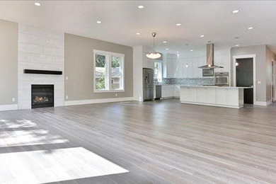 Eat-in kitchen - mid-sized l-shaped light wood floor eat-in kitchen idea in Portland with an undermount sink, shaker cabinets, white cabinets, quartzite countertops, white appliances and an island