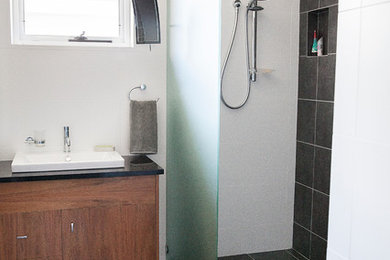 Contemporary bathroom in Brisbane with a drop-in sink, an open shower, black tile and white walls.
