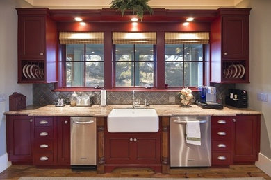 Photo of an eclectic eat-in kitchen in Atlanta with a farmhouse sink, beaded inset cabinets, red cabinets, granite benchtops, stainless steel appliances, medium hardwood floors and multiple islands.