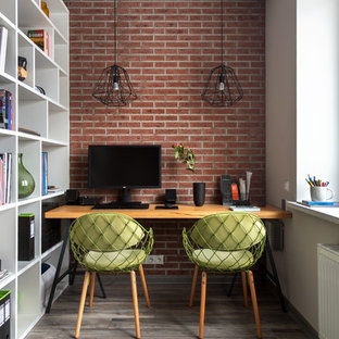 Inspiration för ett litet funkis hemmabibliotek, med laminatgolv, ett fristående skrivbord och röda väggar