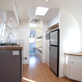 Small contemporary kitchen pantry remodeling - Example of a small trendy galley bamboo floor kitchen pantry design in Santa Barbara with flat-panel cabinets, gray cabinets, wood countertops, blue backsplash, glass tile backsplash, stainless steel appliances and a double-bowl sink