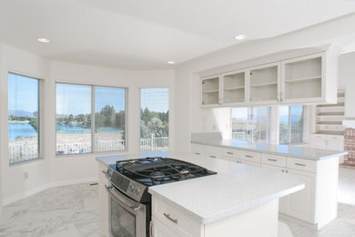 Mid-sized elegant u-shaped marble floor eat-in kitchen photo in Other with a double-bowl sink, shaker cabinets, white cabinets, quartz countertops, stainless steel appliances and an island