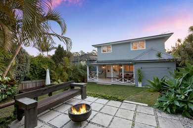 Mid-sized beach style two-storey grey house exterior in Sydney with concrete fiberboard siding, a hip roof and a metal roof.