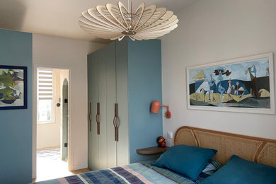 Idée de décoration pour une chambre parentale nordique de taille moyenne avec un mur beige, parquet clair, aucune cheminée et un sol marron.