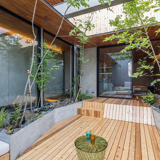 他の地域のコンテンポラリースタイルのおしゃれな中庭のテラス (デッキ材舗装、張り出し屋根) の写真