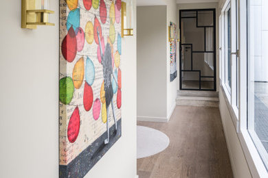 Trendy dark wood floor and brown floor hallway photo in Other with beige walls