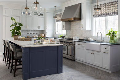Inspiration for a large transitional l-shaped ceramic tile and beige floor eat-in kitchen remodel in New York with a farmhouse sink, flat-panel cabinets, blue cabinets, marble countertops, white backsplash, marble backsplash, paneled appliances, an island and white countertops