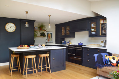 Design ideas for a modern open plan kitchen in Devon with shaker cabinets and with island.