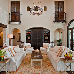 Imagen de salón para visitas abierto, mediterráneo, extra grande, sin televisor, con paredes blancas, suelo de madera en tonos medios, chimenea tradicional, marco de chimenea de piedra y suelo marrón