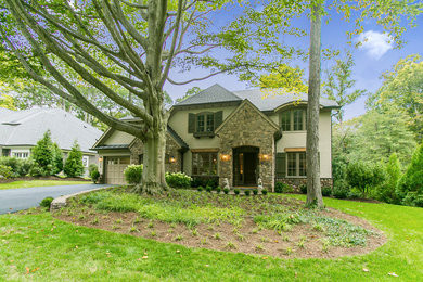 Example of a large arts and crafts beige two-story stone exterior home design in DC Metro