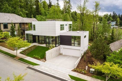 Foto de fachada de casa blanca minimalista de tamaño medio de dos plantas con revestimientos combinados, tejado plano y tejado de varios materiales