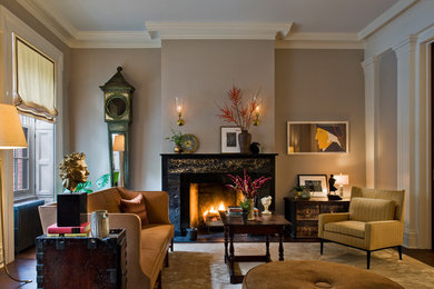 Photo of a mid-sized transitional formal enclosed living room in New York with beige walls, a standard fireplace, a stone fireplace surround, dark hardwood floors, no tv and brown floor.