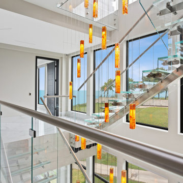 Sculptural glass chandelier cascading through a three-story staircase