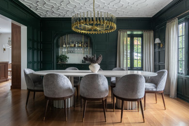 Design ideas for a large transitional dining room in New York with green walls, light hardwood floors and brown floor.