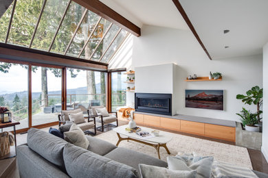 Living room - large contemporary open concept porcelain tile and brown floor living room idea in Vancouver with white walls, a standard fireplace, a metal fireplace and a wall-mounted tv