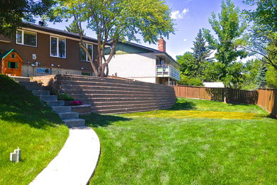 Design ideas for a large traditional backyard landscaping in Calgary.