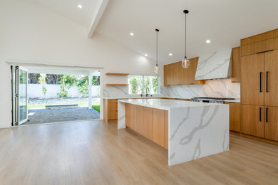 Example of a trendy l-shaped open concept kitchen design in Orange County with flat-panel cabinets, medium tone wood cabinets and quartz countertops
