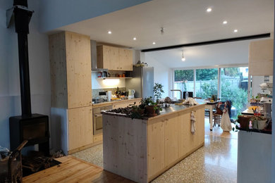 Réalisation d'une cuisine ouverte champêtre avec des portes de placard beiges, un plan de travail en bois et îlot.