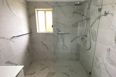 Inspiration for a mid-sized contemporary bathroom in Sydney with flat-panel cabinets, white cabinets, white tile, ceramic tile, white benchtops, a single vanity and a freestanding vanity.