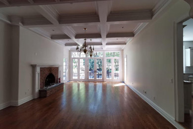 Inspiration for a large timeless formal and open concept medium tone wood floor, brown floor and coffered ceiling living room remodel in Hawaii with beige walls, a standard fireplace, a brick fireplace and no tv