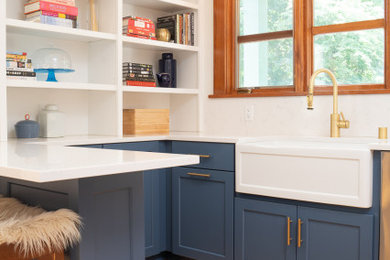 Kitchen - transitional light wood floor kitchen idea in Minneapolis with a farmhouse sink, flat-panel cabinets, blue cabinets, quartz countertops, white backsplash, quartz backsplash and white countertops