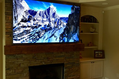 Mid-sized trendy home theater photo in Birmingham with beige walls and a wall-mounted tv