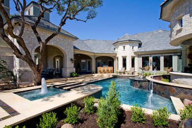 Mid-sized traditional courtyard custom-shaped pool in Austin with a water feature and decking.
