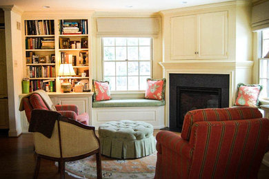 Example of a mid-sized classic open concept medium tone wood floor living room library design in Philadelphia with white walls, a standard fireplace, a wood fireplace surround and a concealed tv