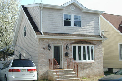 Mid-sized elegant beige two-story mixed siding exterior home photo in New York with a shingle roof