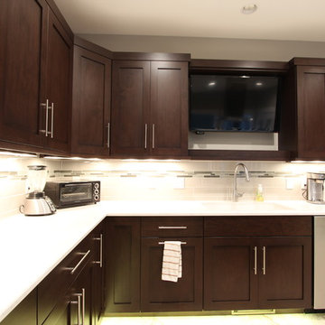 TV Above Kitchen Sink Flanked by Dark Cabinets