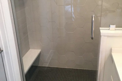 Alcove shower - contemporary white tile and porcelain tile porcelain tile and black floor alcove shower idea in Nashville with a hinged shower door