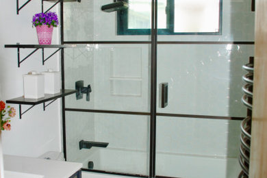 Small trendy kids' black and white tile and ceramic tile ceramic tile and black floor bathroom photo in Los Angeles with furniture-like cabinets, black cabinets, a one-piece toilet, white walls, a drop-in sink, quartz countertops, a hinged shower door and white countertops