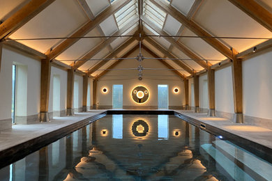 Design ideas for a large contemporary indoor above ground swimming pool in Dorset with a pool house.