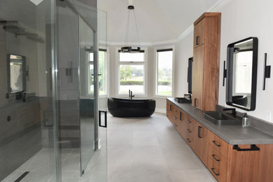 Example of a mid-sized minimalist gray tile and stone slab porcelain tile, gray floor, double-sink and vaulted ceiling bathroom design in Dallas with flat-panel cabinets, medium tone wood cabinets, a bidet, white walls, a vessel sink, gray countertops and a floating vanity