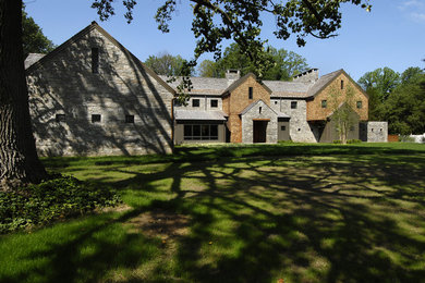 Huge trendy gray two-story stone exterior home photo in New York