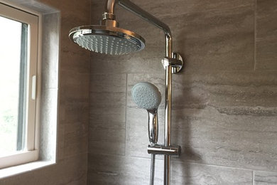 Alcove shower - traditional beige tile and slate tile alcove shower idea in San Francisco with tile countertops and a hinged shower door