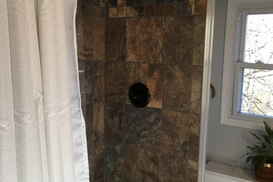Photo of a small country bathroom in Richmond with furniture-like cabinets, white cabinets, an open shower, a two-piece toilet, multi-coloured tile, ceramic tile, grey walls, ceramic floors and an integrated sink.
