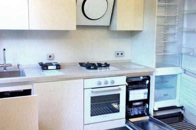 Photo of a small contemporary single-wall enclosed kitchen in Other with a built-in sink, flat-panel cabinets, beige cabinets, composite countertops, beige splashback, glass sheet splashback, white appliances, ceramic flooring and no island.