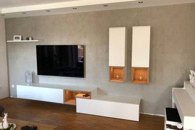 Großes, Offenes Modernes Musikzimmer ohne Kamin mit grauer Wandfarbe, braunem Holzboden, TV-Wand und braunem Boden in Sonstige