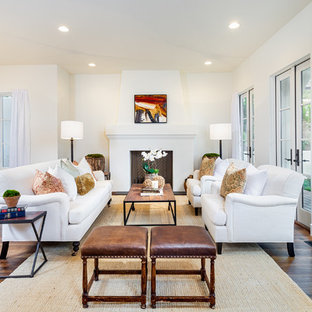 Repräsentatives, Offenes Mediterranes Wohnzimmer mit weißer Wandfarbe, dunklem Holzboden und Kamin in San Diego
