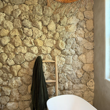 Freestanding Tub Against Limestone Feature Wall