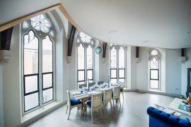 Medium sized victorian open plan dining room in London with white walls and light hardwood flooring.