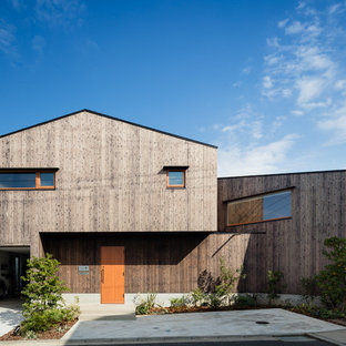 他の地域のビーチスタイルのおしゃれな二階建ての家 (切妻屋根、戸建、金属屋根、木材サイディング、茶色い外壁) の写真