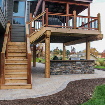 Stone Kitchen Beneath Wood Staircase and Outdoor Dining Room