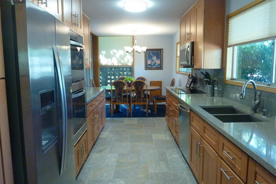 Example of a mid-sized arts and crafts galley ceramic tile and gray floor eat-in kitchen design in Orange County with an undermount sink, shaker cabinets, light wood cabinets, quartz countertops, blue backsplash, glass tile backsplash, stainless steel appliances and no island