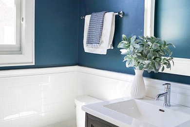 Inspiration for a small contemporary white tile and porcelain tile porcelain tile and gray floor powder room remodel in Chicago with furniture-like cabinets, brown cabinets, a two-piece toilet, blue walls, a drop-in sink, quartz countertops and white countertops