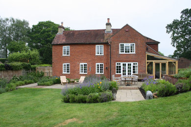 Photo of a traditional back formal garden with natural stone paving.