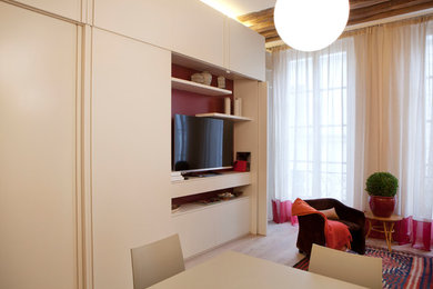 This is an example of a mid-sized transitional open concept living room in Paris with a library, beige walls, light hardwood floors, no fireplace, brown floor and a concealed tv.